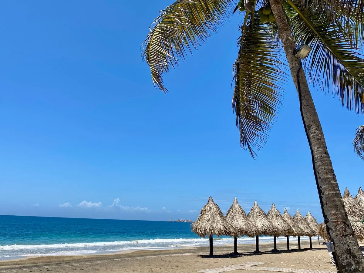 Beach with palm-leaf shades and turquoise water on Margarita Island